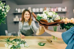 O florista dá o ramalhete fresco ao cliente fêmea Foto de Stock O florista dá o ramalhete fresco ao cliente fêmea Foto de Stock