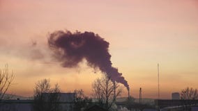 O fumo das tubulações das caldeiras e das casas no inverno contra o céu do por do sol, traços de planos do voo no céu filme O fumo das tubulações das caldeiras e das casas no inverno contra o céu do por do sol, traços de planos do voo no céu filme