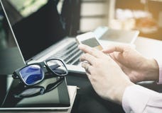 O funcionamento do escritório está usando o telefone na tabela do escritório imagem de stock O funcionamento do escritório está usando o telefone na tabela do escritório imagem de stock