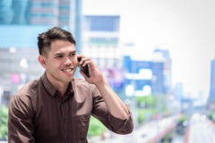 O funcionamento e a operação asiáticos do homem de negócios em wi exteriores do escritório foto de stock royalty free O funcionamento e a operação asiáticos do homem de negócios em wi exteriores do escritório foto de stock royalty free
