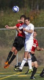 O futebol de Canadá dois jogadores salta o encabeçamento imagem de stock O futebol de Canadá dois jogadores salta o encabeçamento imagem de stock