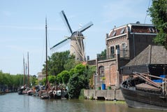 O Gouda holandês da arquitectura da cidade com canal-moinho de vento-envia foto de stock O Gouda holandês da arquitectura da cidade com canal-moinho de vento-envia foto de stock