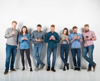 O grupo de meninos e de meninas conectou com seus smartphones Conceito do Internet e da rede social imagem de stock O grupo de meninos e de meninas conectou com seus smartphones Conceito do Internet e da rede social imagem de stock