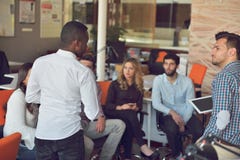 O grupo dos jovens no escritório moderno tem a reunião e a sessão de reflexão da equipe ao trabalhar no portátil e no café bebend imagens de stock O grupo dos jovens no escritório moderno tem a reunião e a sessão de reflexão da equipe ao trabalhar no portátil e no café bebend imagens de stock