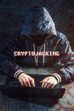 O hacker anônimo sem uma cara está tentando roubar o cryptocurrency usando um computador Fraude e decepção em Cryptojacking foto de stock royalty free O hacker anônimo sem uma cara está tentando roubar o cryptocurrency usando um computador Fraude e decepção em Cryptojacking foto de stock royalty free