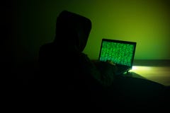 O hacker encapuçado está usando seu computador cortando o servidor imagem de stock O hacker encapuçado está usando seu computador cortando o servidor imagem de stock