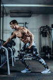 O homem atlético do poder considerável no treinamento da dieta que bombeia acima muscles com peso e barbell Halterofilista forte, imagem de stock O homem atlético do poder considerável no treinamento da dieta que bombeia acima muscles com peso e barbell Halterofilista forte, imagem de stock