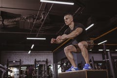 O homem atlético que executa o crossfit malha na caixa do crossfit fotos de stock O homem atlético que executa o crossfit malha na caixa do crossfit fotos de stock