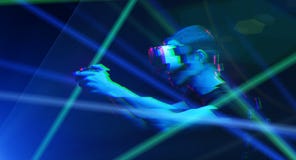 O homem com os auriculares da realidade virtual est? jogando o jogo Imagem com efeito do pulso aleat?rio fotografia de stock O homem com os auriculares da realidade virtual est? jogando o jogo Imagem com efeito do pulso aleat?rio fotografia de stock