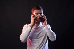 O homem de negócios fala em dois telefones e gritos do overstrain e fotografia de stock royalty free O homem de negócios fala em dois telefones e gritos do overstrain e fotografia de stock royalty free