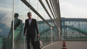O homem de negócios farpado elegante ajusta seu revestimento antes que curso do trabalho filme O homem de negócios farpado elegante ajusta seu revestimento antes que curso do trabalho filme