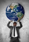 O homem de negócios sustenta a terra do planeta fotografia de stock O homem de negócios sustenta a terra do planeta fotografia de stock