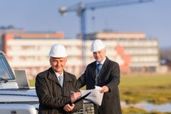 O homem do arquiteto faz anotações no canteiro de obras fotografia de stock O homem do arquiteto faz anotações no canteiro de obras fotografia de stock