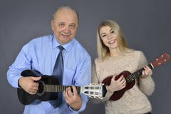 O homem e a mulher jogam a guitarra fotografia de stock royalty free O homem e a mulher jogam a guitarra fotografia de stock royalty free