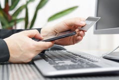 O homem está usando o cartão e o telefone celular de crédito para na linha pagamento O homem está usando o cartão e o telefone celular de crédito para na linha pagamento