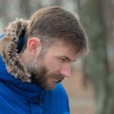 O homem farpado olha para baixo Homem farpado Homem do retrato olhar No parque da cidade Fotos de Stock O homem farpado olha para baixo Homem farpado Homem do retrato olhar No parque da cidade Fotos de Stock