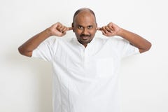 O homem indiano do negócio ocasional maduro cobriu as orelhas fotografia de stock O homem indiano do negócio ocasional maduro cobriu as orelhas fotografia de stock