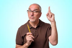 O homem latino-americano maduro tem uma boa ideia que está no fundo azul O professor está guardando o lápis fotografia de stock royalty free O homem latino-americano maduro tem uma boa ideia que está no fundo azul O professor está guardando o lápis fotografia de stock royalty free