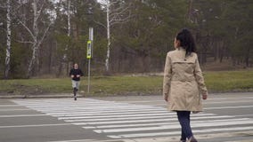 O homem novo e a mulher andam através da estrada transversaa e caem no amor em se video estoque O homem novo e a mulher andam através da estrada transversaa e caem no amor em se video estoque