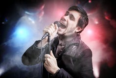 O homem novo feliz está cantando a música no clube do disco na noite foto de stock royalty free O homem novo feliz está cantando a música no clube do disco na noite foto de stock royalty free