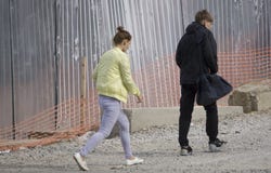 O indivíduo com a menina está perto obras canteiro Rússia Berezniki do 4 de setembro de 2017 imagem de stock O indivíduo com a menina está perto obras canteiro Rússia Berezniki do 4 de setembro de 2017 imagem de stock