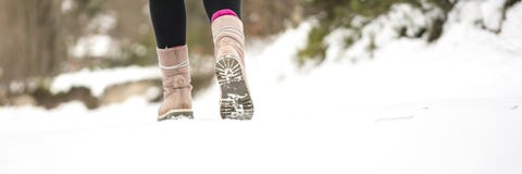O inverno aventura-se - o close up do passeio fêmea morno das botas do inverno Foto de Stock O inverno aventura-se - o close up do passeio fêmea morno das botas do inverno Foto de Stock