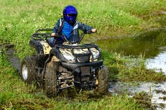 O menino está viajando em um ATV imagens de stock royalty free O menino está viajando em um ATV imagens de stock royalty free