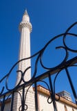 O minarete de mesquitas muçulmanas e um fragmento de cerca feita do metal fotografia de stock royalty free O minarete de mesquitas muçulmanas e um fragmento de cerca feita do metal fotografia de stock royalty free