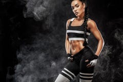 O modelo afro-americano bonito desportivo, mulher no sportwear faz a aptidão que exercita no fundo preto para ficar apto foto de stock O modelo afro-americano bonito desportivo, mulher no sportwear faz a aptidão que exercita no fundo preto para ficar apto foto de stock