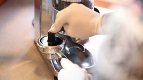 O moedor de café derrama o café à terra no suporte e em tamping o filme O moedor de café derrama o café à terra no suporte e em tamping o filme