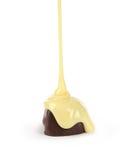 O molho do leite doce é derramado em uma barra de chocolate Imagens de Stock O molho do leite doce é derramado em uma barra de chocolate Imagens de Stock