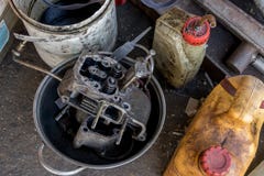 O motor diesel sujo na bandeja de alumínio com óleo engarrafa - reciclando - a garagem do vintage fotografia de stock O motor diesel sujo na bandeja de alumínio com óleo engarrafa - reciclando - a garagem do vintage fotografia de stock