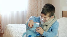 O Nebulizer para a inalação, criança doente respira através do nebulizer, bebê faz a inalação, menino com uma máscara de oxigênio video estoque O Nebulizer para a inalação, criança doente respira através do nebulizer, bebê faz a inalação, menino com uma máscara de oxigênio video estoque