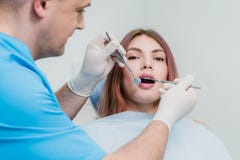 O orthodontist do doutor examina a cavidade oral de um paciente bonito imagens de stock royalty free O orthodontist do doutor examina a cavidade oral de um paciente bonito imagens de stock royalty free