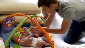 O paizinho põe sua filha pequena sobre uma esteira tornando-se O paizinho põe sua filha pequena sobre uma esteira tornando-se