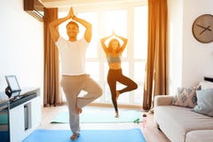 O par afro-americano que faz a ioga exercita em casa Estão no assoalho em esteiras da ioga foto de stock royalty free O par afro-americano que faz a ioga exercita em casa Estão no assoalho em esteiras da ioga foto de stock royalty free