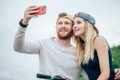 O par que toma a ruptura da equitação bikes para tomar o tiro dos selfies fotos de stock royalty free O par que toma a ruptura da equitação bikes para tomar o tiro dos selfies fotos de stock royalty free