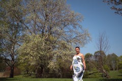 O passeio, o corredor novos da mulher gravida do viajante, girando ao redor e apreciam seu tempo livre do lazer em um parque com imagens de stock O passeio, o corredor novos da mulher gravida do viajante, girando ao redor e apreciam seu tempo livre do lazer em um parque com imagens de stock