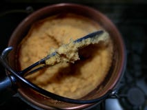 O Polenta amarelo tradicional da farinha de milho de Bergamo cozinhou em um caldeirão no fogo, fundo preto - alimento típico nort fotografia de stock royalty free O Polenta amarelo tradicional da farinha de milho de Bergamo cozinhou em um caldeirão no fogo, fundo preto - alimento típico nort fotografia de stock royalty free
