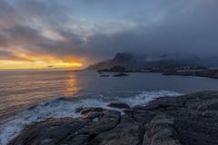 O por do sol sobre o mar toma uma foto da vila de Hamnoy em ilhas de Lofoten foto de stock royalty free O por do sol sobre o mar toma uma foto da vila de Hamnoy em ilhas de Lofoten foto de stock royalty free
