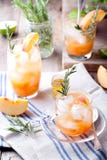 O pêssego e os alecrins efervescem o cocktail fotografia de stock O pêssego e os alecrins efervescem o cocktail fotografia de stock