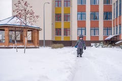O rapaz pequeno limpa trajetos da pá na jarda da neve imagens de stock O rapaz pequeno limpa trajetos da pá na jarda da neve imagens de stock