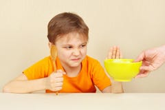 O rapaz pequeno recusa comer o cereal Fotografia de Stock O rapaz pequeno recusa comer o cereal Fotografia de Stock