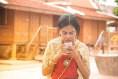 O retrato da fêmea asiática em vestidos tradicionais levanta o móbil do uso foto de stock O retrato da fêmea asiática em vestidos tradicionais levanta o móbil do uso foto de stock