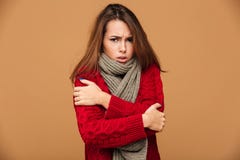 O retrato da mulher moreno de congelação triste no vermelho fez malha a camiseta s Fotos de Stock O retrato da mulher moreno de congelação triste no vermelho fez malha a camiseta s Fotos de Stock