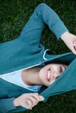 O retrato da mulher nova e desportiva no sportswear encontra-se na grama no parque imagens de stock royalty free O retrato da mulher nova e desportiva no sportswear encontra-se na grama no parque imagens de stock royalty free