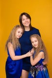 O retrato de meninas bonitas no azul veste-se em um backgrou amarelo imagem de stock royalty free O retrato de meninas bonitas no azul veste-se em um backgrou amarelo imagem de stock royalty free