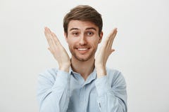 O retrato do sentimento novo considerável do empresário aliviado e feliz, aumentando as palmas aproxima a cara, o sorriso amplame fotografia de stock O retrato do sentimento novo considerável do empresário aliviado e feliz, aumentando as palmas aproxima a cara, o sorriso amplame fotografia de stock