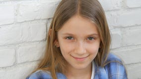 O retrato pensativo da criança, cara de sorriso da criança que olha in camera o louro furou a menina foto de stock O retrato pensativo da criança, cara de sorriso da criança que olha in camera o louro furou a menina foto de stock