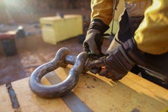 O Rigger que veste uma inspeção da luva da segurança, etiquetando o guindaste da segurança que levanta o equipamento de 17 tons c imagem de stock O Rigger que veste uma inspeção da luva da segurança, etiquetando o guindaste da segurança que levanta o equipamento de 17 tons c imagem de stock